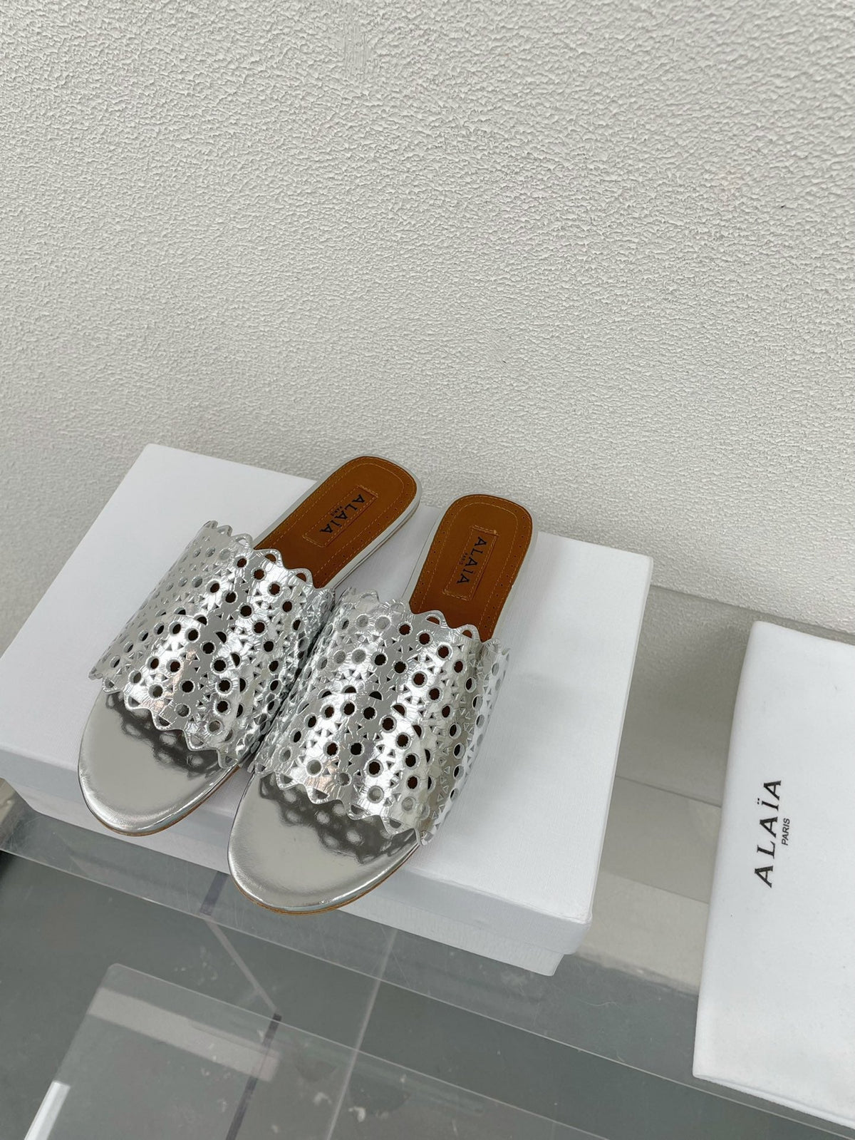 ALAIA VIENNE FLAT MULES IN SILVER LAMBSKIN